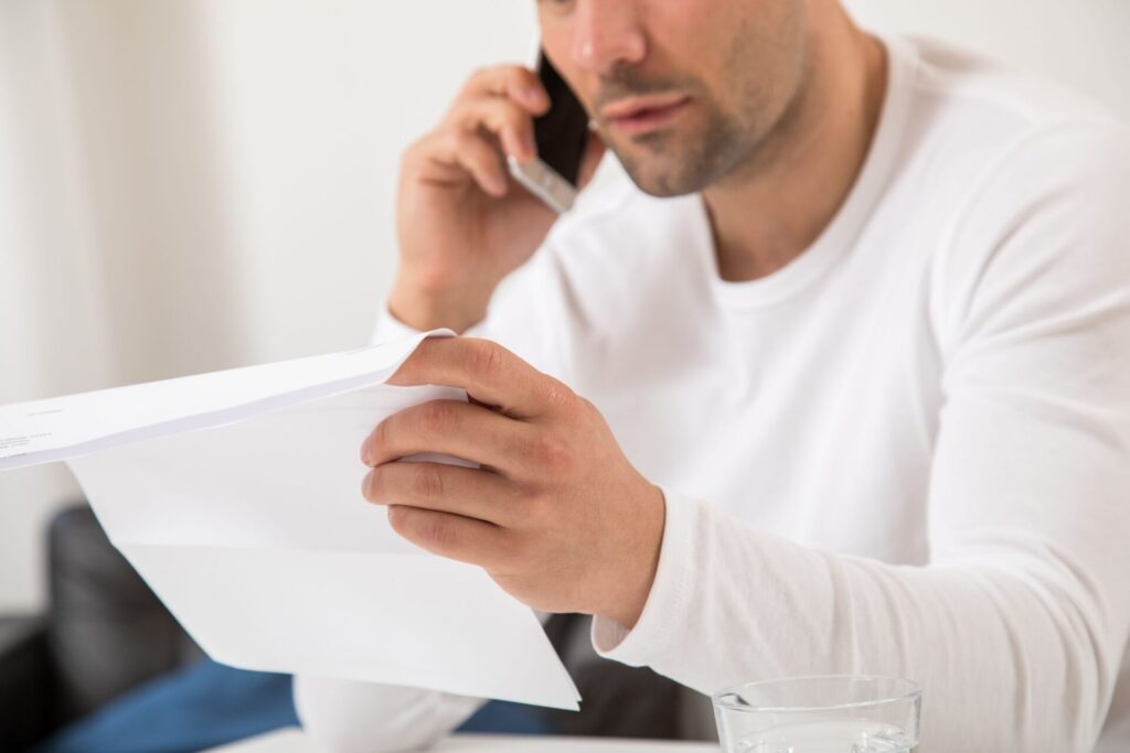Ein Mann telefoniert und hält einen Brief in der Hand