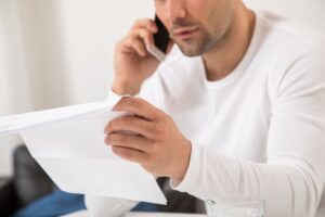 Ein Mann telefoniert und hält einen Brief in der Hand